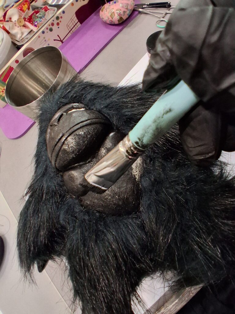 Monkey — Μια Ιστορία Επιστροφής Εφαρμογή ειδικής βαφής με πινέλο στο ανάγλυφο δερμάτινο πρόσωπο του Monkey στο εργαστήριο Eugenia-Lab.